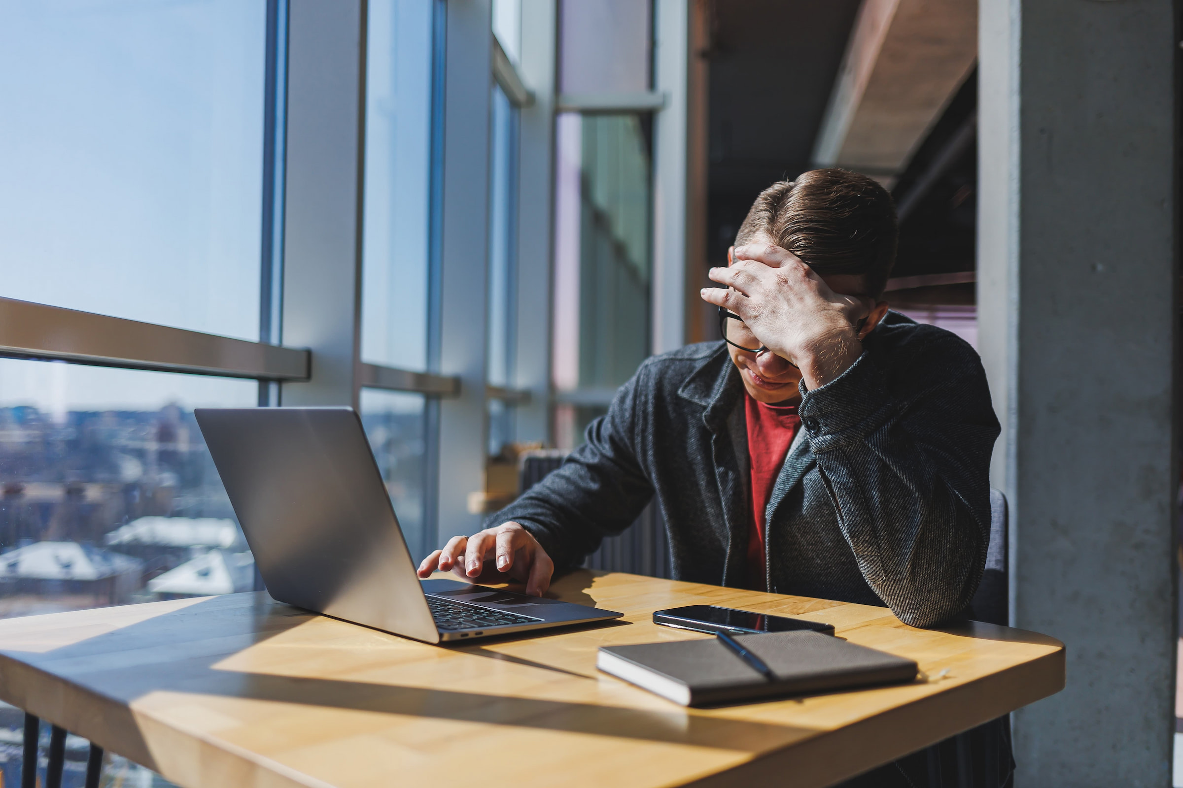 man looking stressed at laptop in office disconnect employee