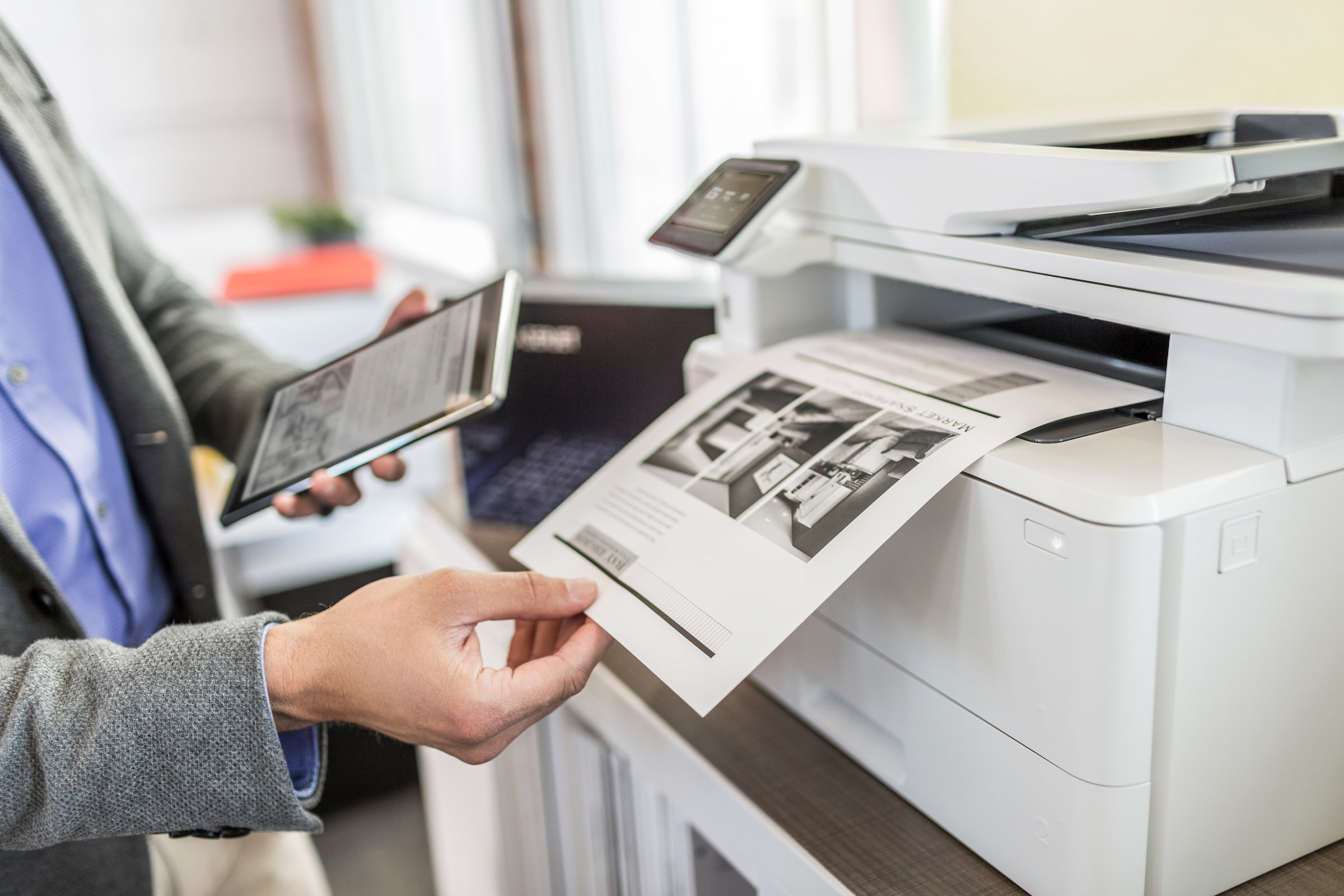 hand holding printed document from HP office printer photocopier