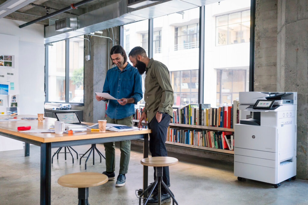 two men at office table large windows managed print services