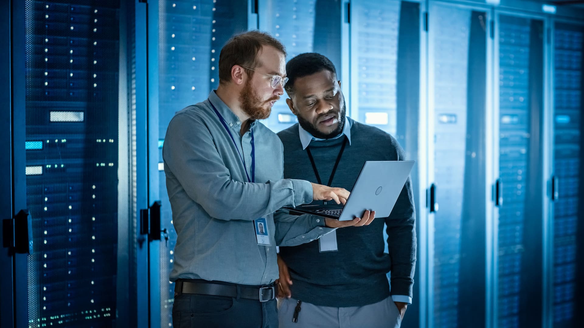 two network men in server room laptop