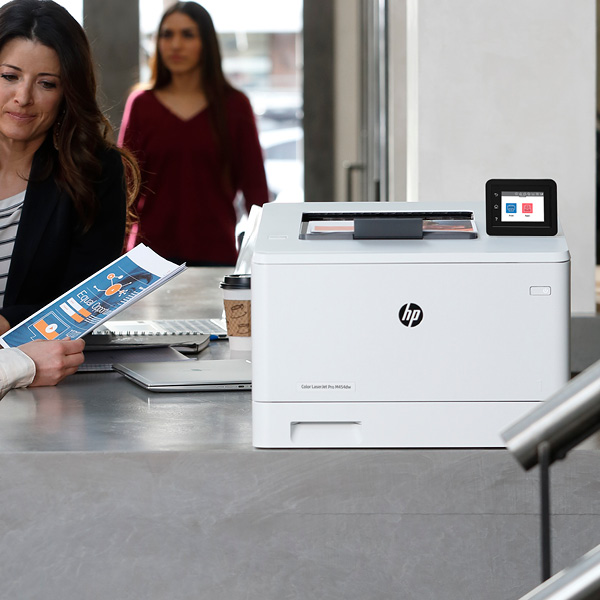 Women standing by HP desktop printer scanner