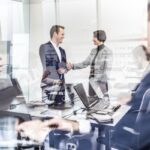 businesspeople in a meeting room behind a window
