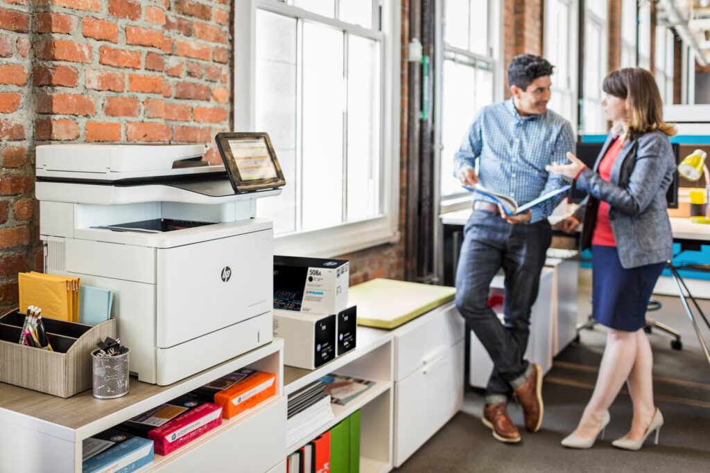 managed print service, man and woman in office chatting, HP printer