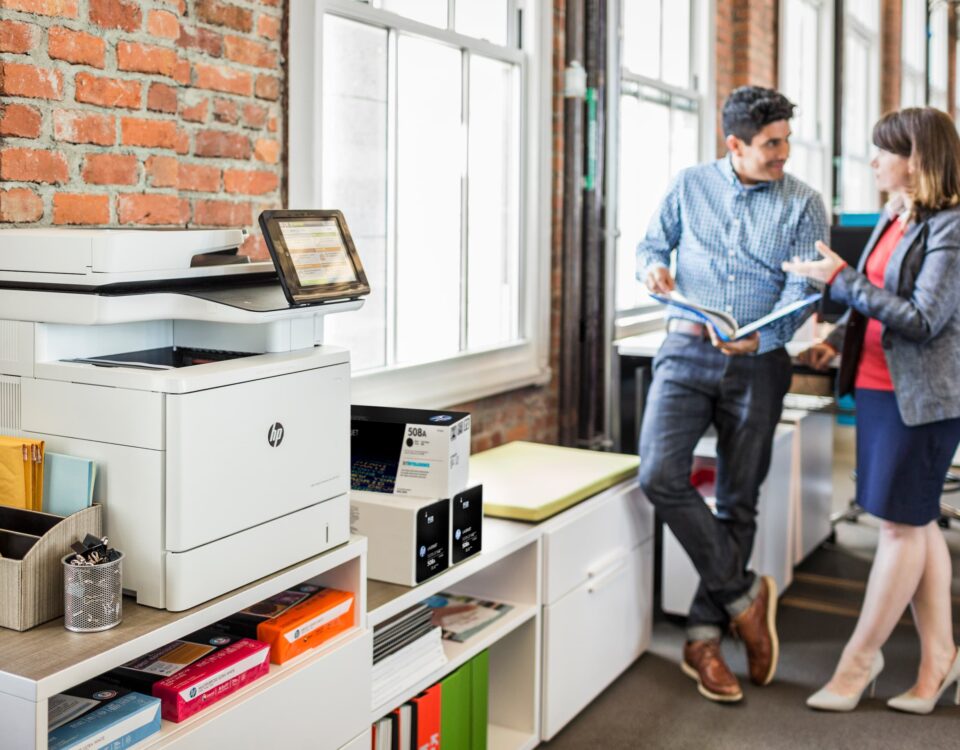 managed print service, man and woman in office chatting, HP printer