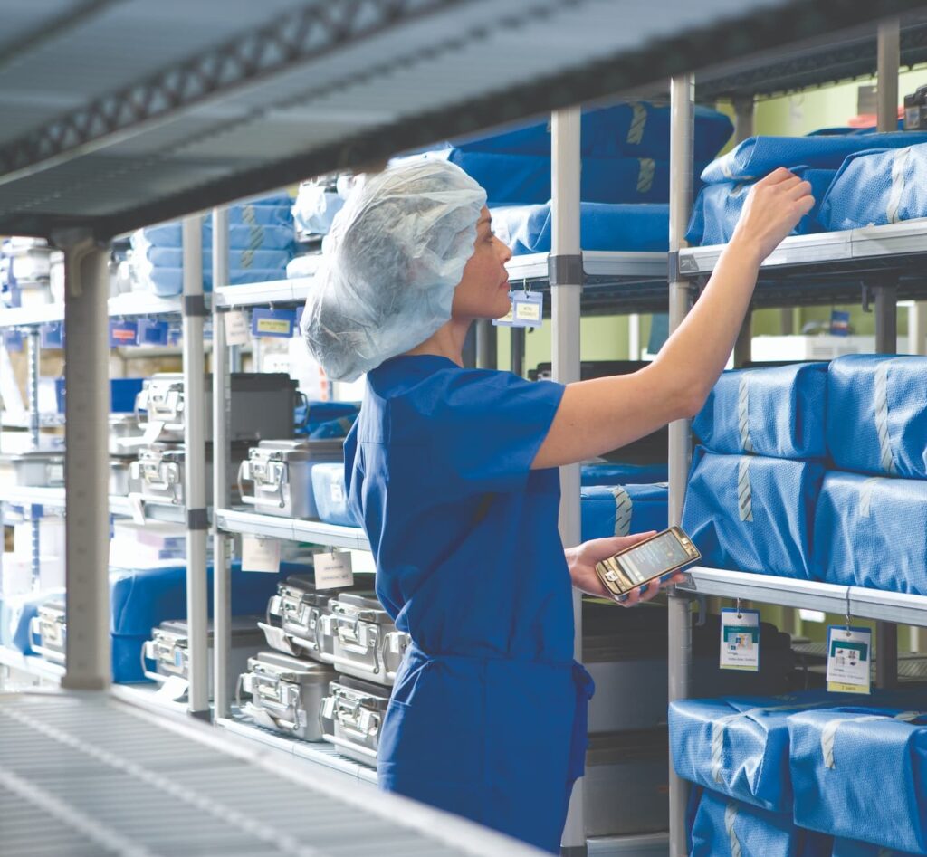 Nurse uses a console to locate items in the backroom storage of a hospital