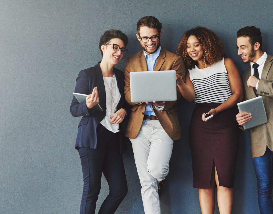 trendy young employees against grey background laptop