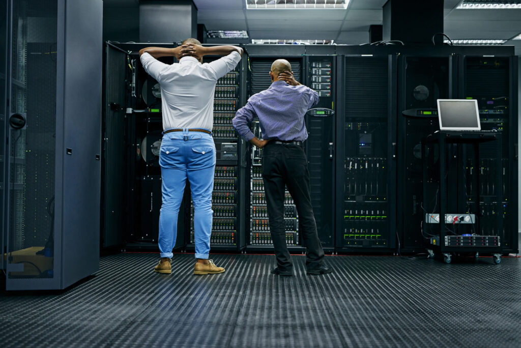 two male stressed it technicians in server room