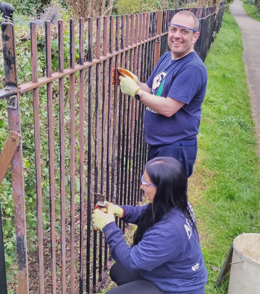 Team Apogee paint a fence at Green Synergy