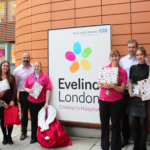 The Apogee and Guy's and St Thomas' team by the Evelina London Charity sign