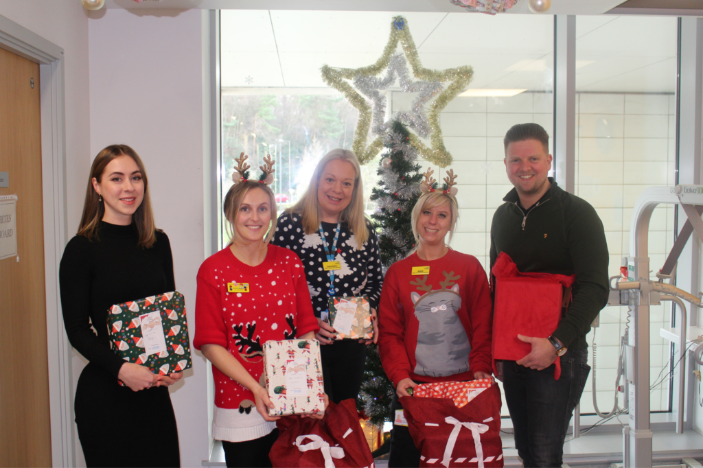 The Maidstone and Tunbridge Wells and Apogee Team holding presents