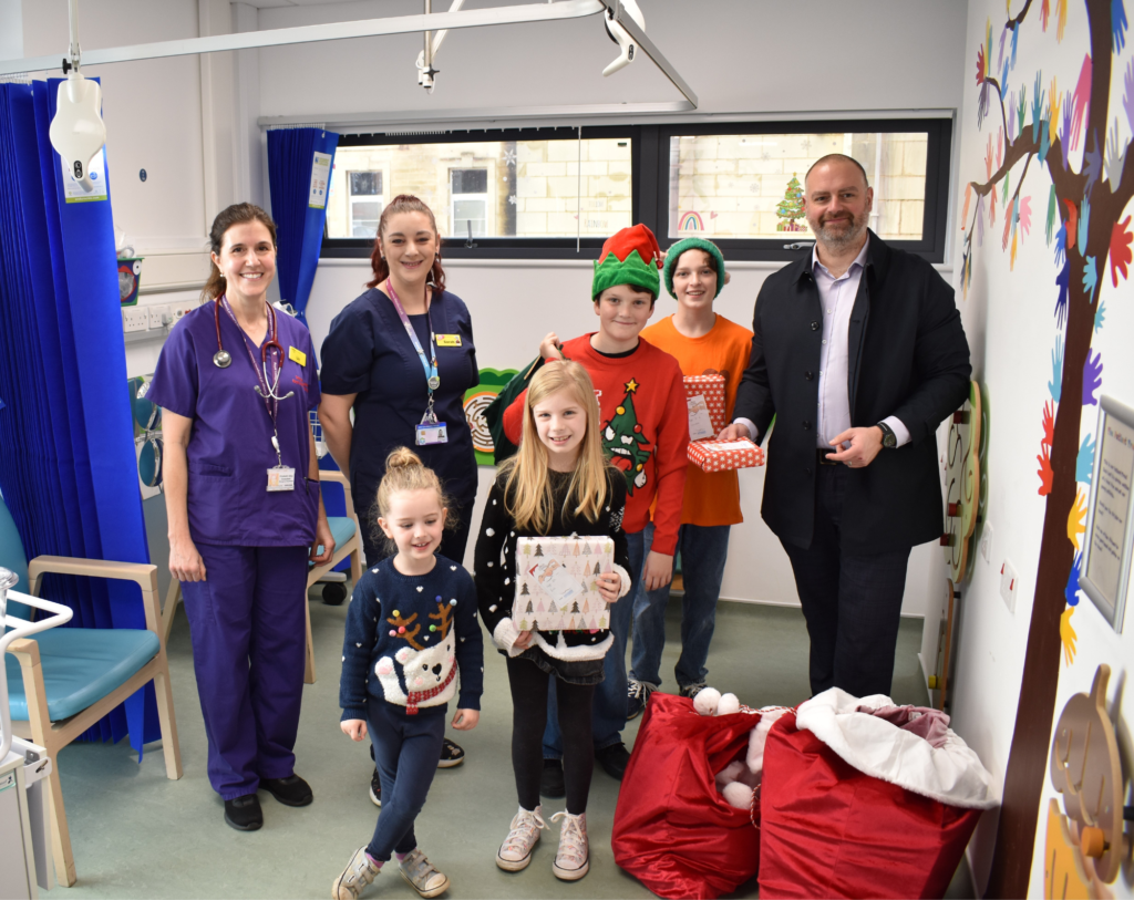 The Royal Bath Team and volunteers and Apogee team holding Christmas presents
