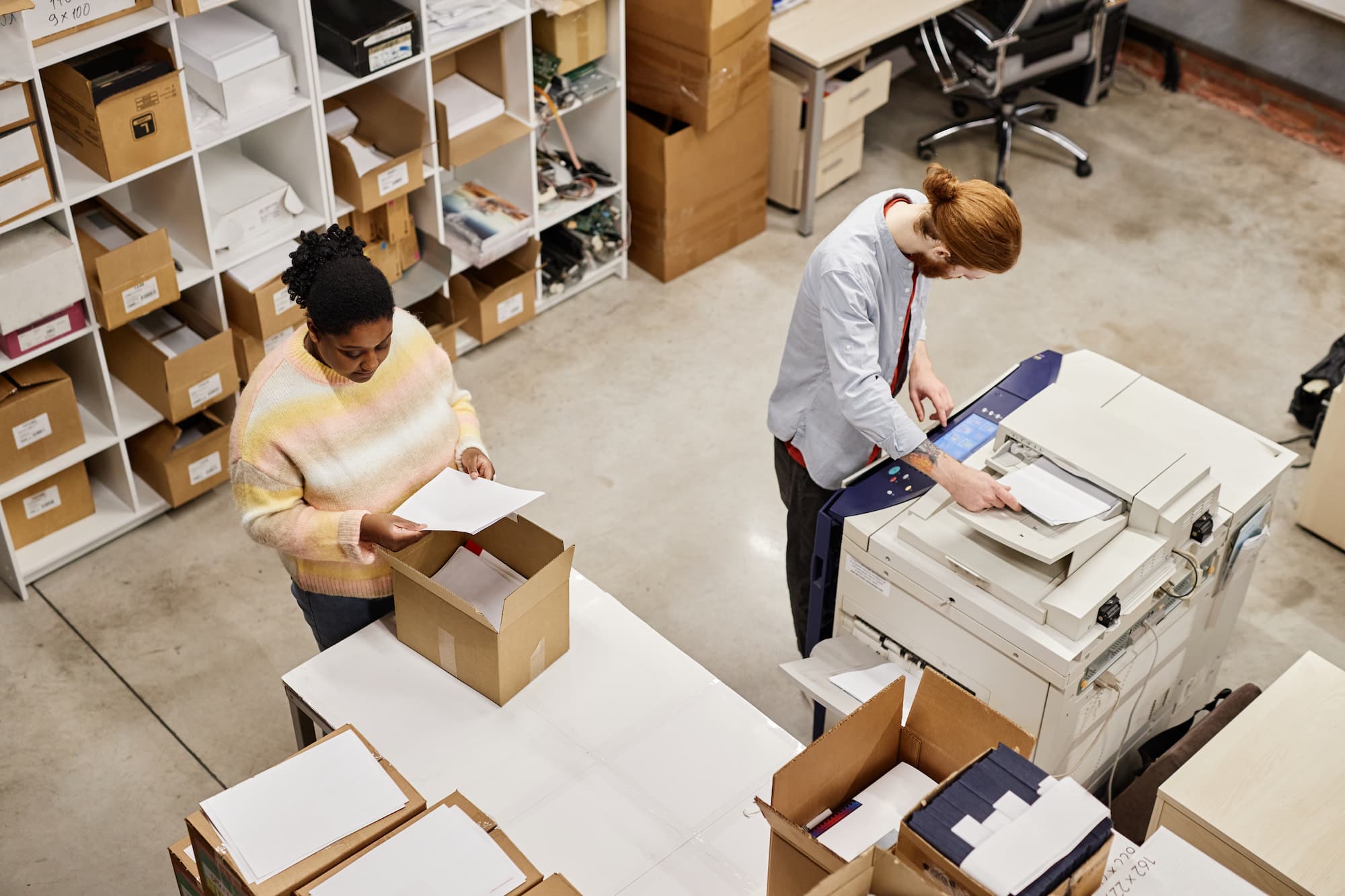 worker scanning while colleague packs boxes