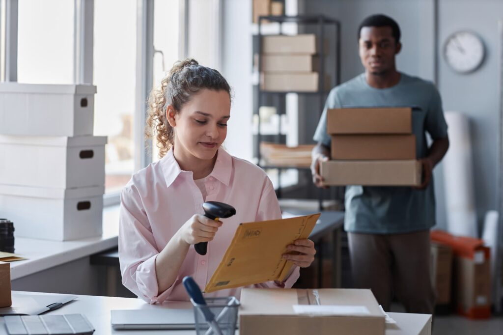 female-worker-of-storage room scanning packed envelope