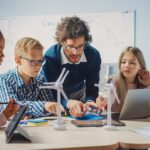 elementary students and teacher in science class with laptop