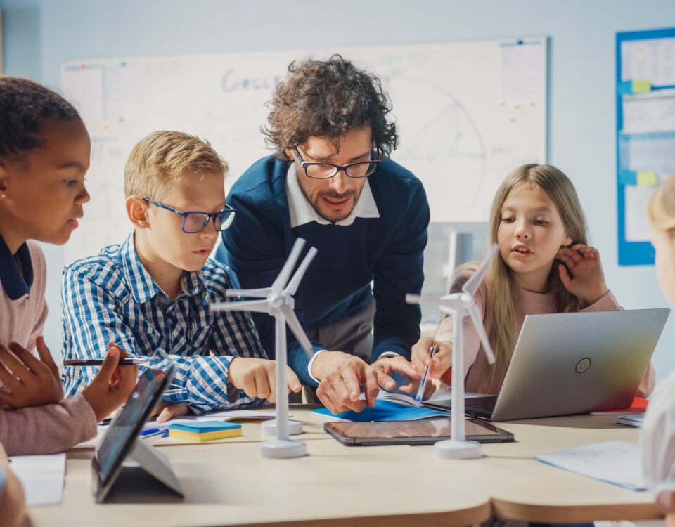 elementary students and teacher in science class with laptop