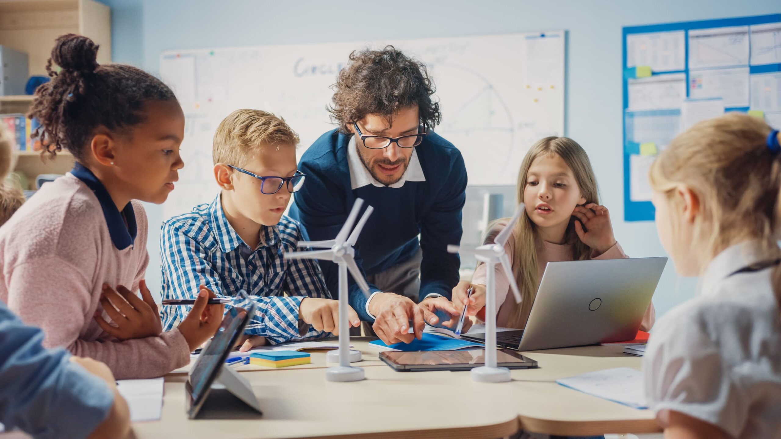 elementary students and teacher in science class with laptop