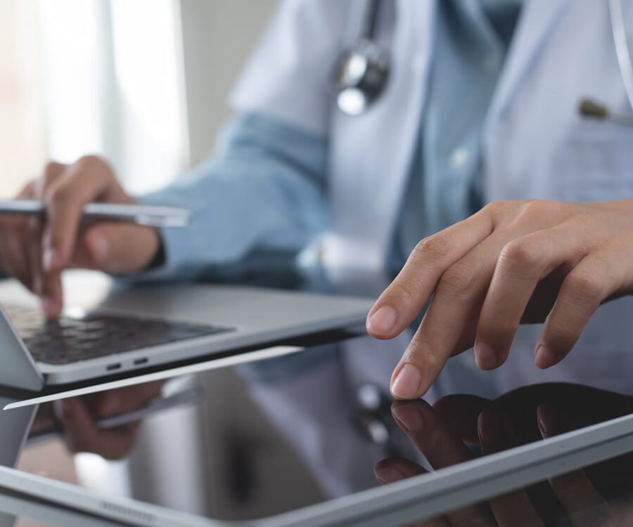 healthcare doctor in office using a laptop and tablet