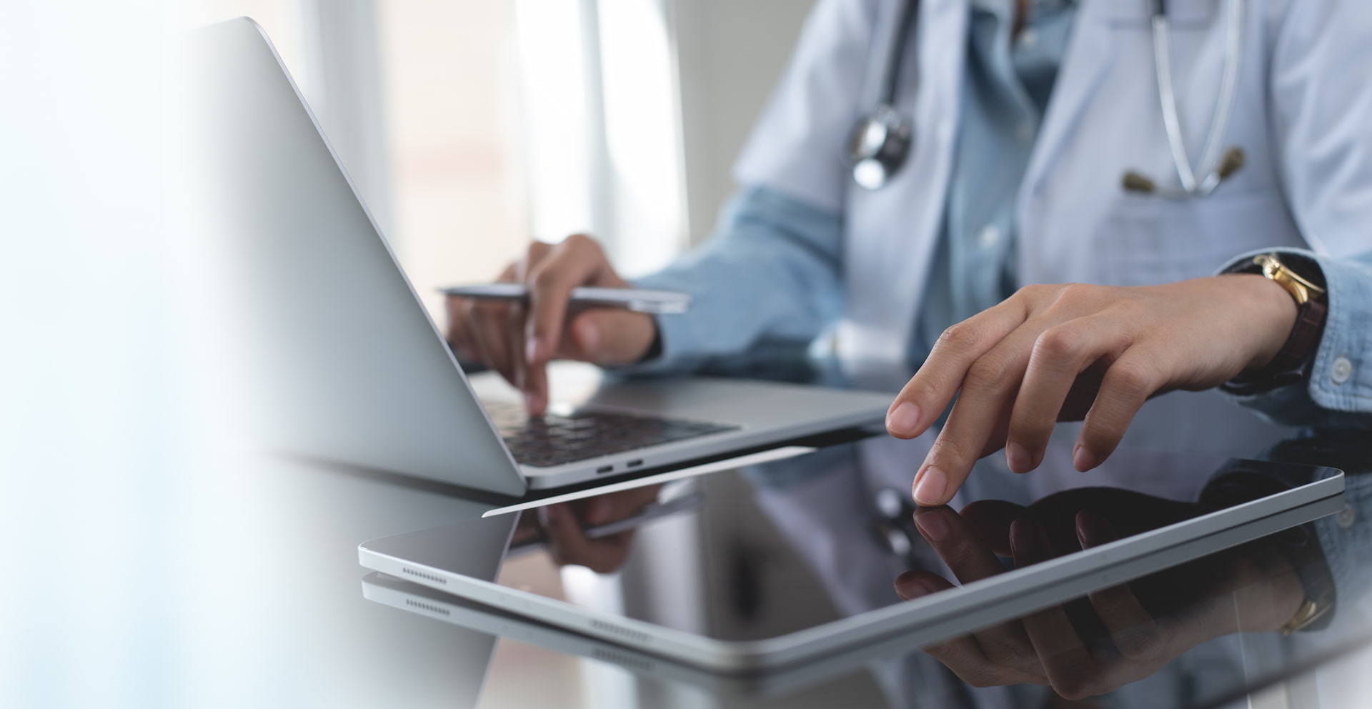 healthcare doctor in office using a laptop and tablet