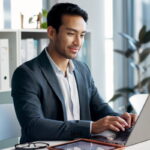 man using laptop tablet in white business office
