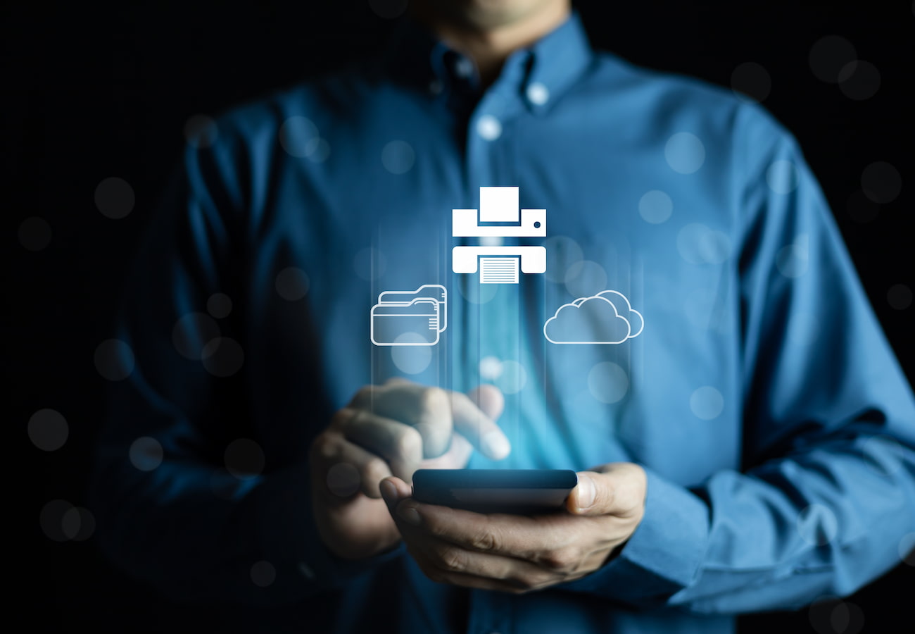 man in blue buttoned shirt using smartphone to manage cloud and printer
